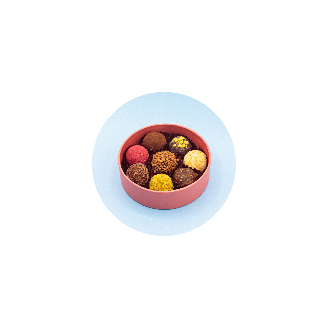 Assorted Ciocco Miami truffles in a pink box on a light blue background